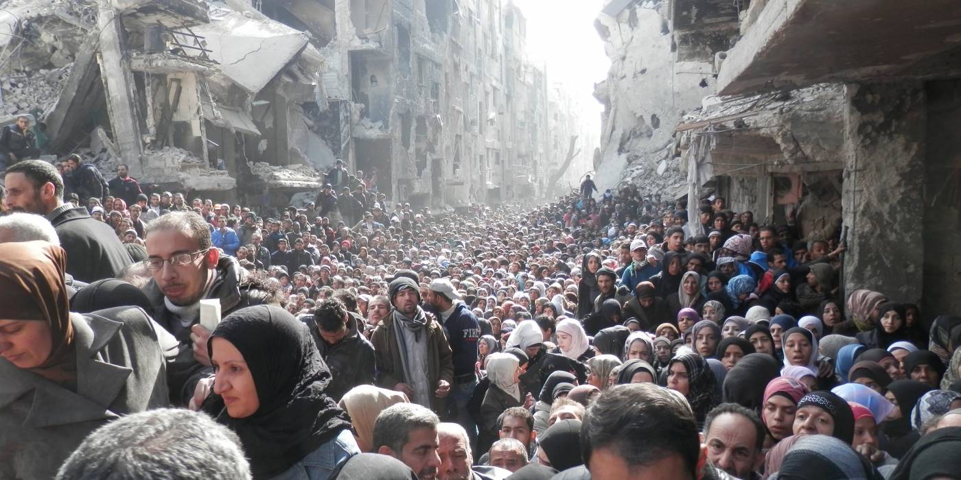 I den palestinske flyktningleiren Yarmouk i Damaskus har tilgangen til mat vært svært begrenset under krigen. Befolkningen står i kø for å få matforsyninger fra FN. (Januar 2014). Foto: Zuma Press/UNRWA