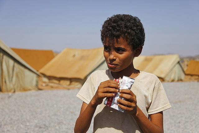 Bildet viser en gutt som spiser mat for nødstilfeller i Mazrak-leiren i 2009, en leir for internt fordrevne nordvest i Jemen. Unicef deler ut mat der til barn for å motvirke underernæring. Foto: Hugh Macleod/IRIN/Flickr